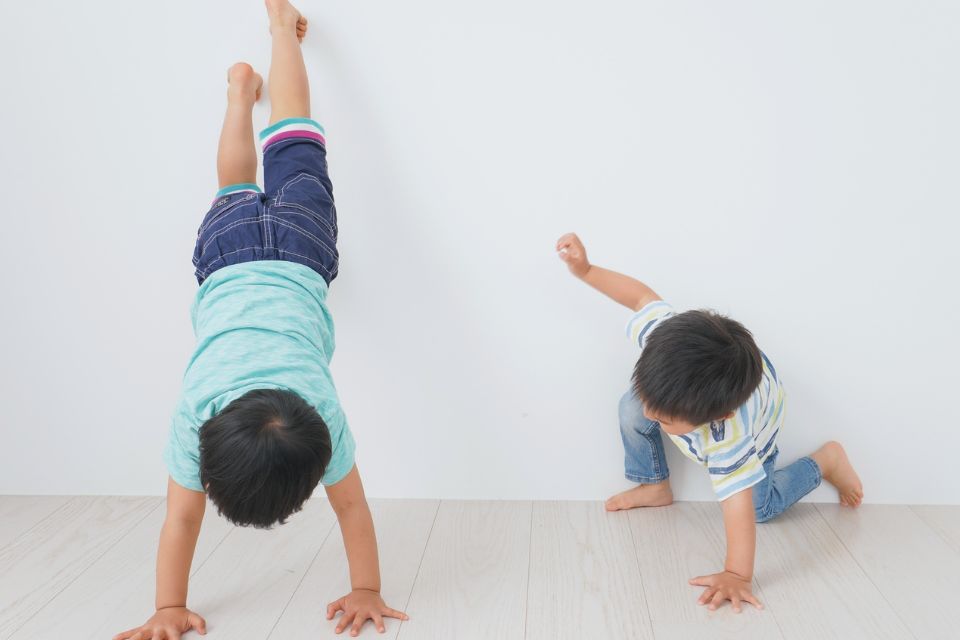 Ernährung bei ADHS | 2 herumtobenden kleinen Jungs. Einer davon macht einen Handstand