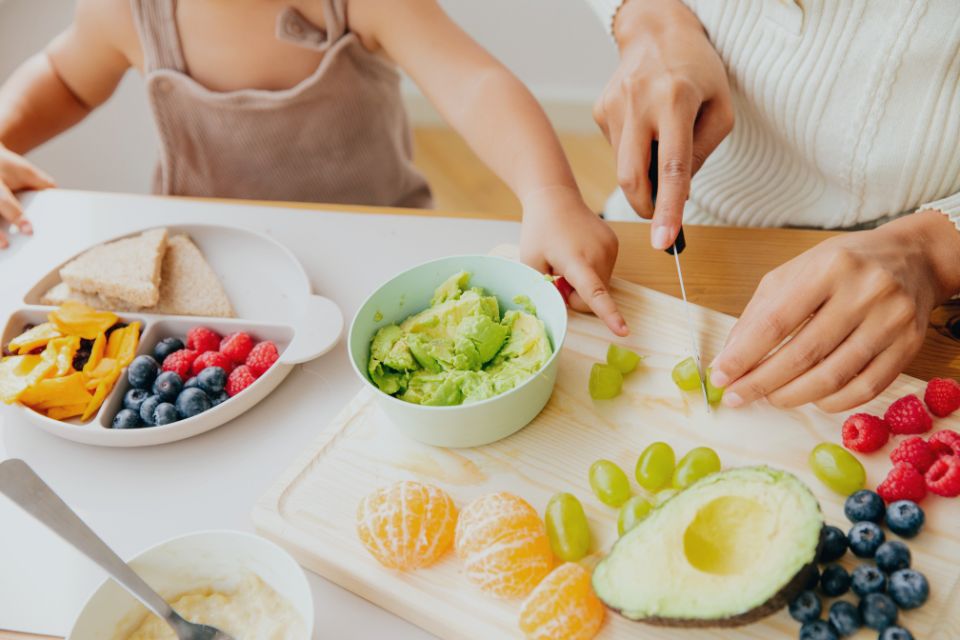 Beikost | ein Kleinkind entdeckt neugierig unbekanntes Essen und zeigt mit dem Zeigefinger drauf.